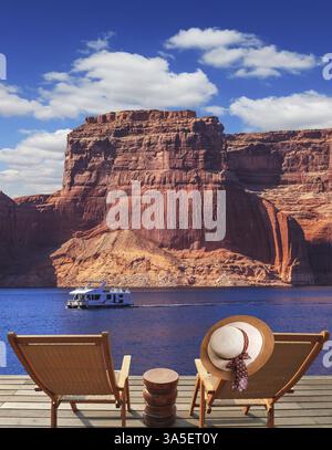 At the stern of the boat are two deck chairs. On the back of one hanging elegant ladies straw hat. Walk to the tourist boat on Lake Powell on the Colo Stock Photo