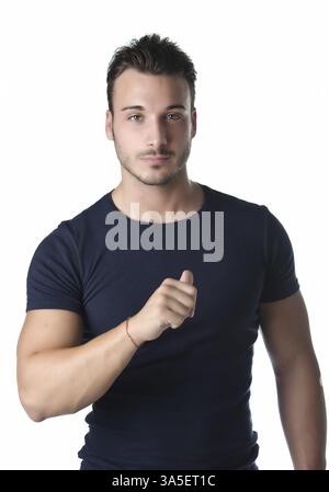 Attractive and athletic young man pointing thumb finger at himself, confident expression Stock Photo