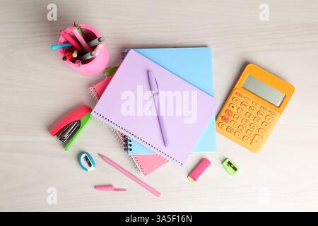 Doing homework. Notebooks and other different stationery on wooden table, flat lay Stock Photo