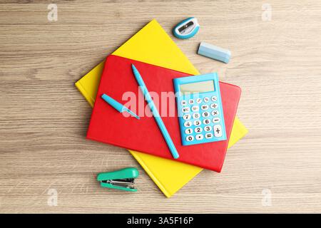 Doing homework. Notebooks and other different stationery on wooden table, flat lay Stock Photo
