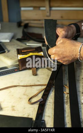 Tailor process leather in workshop. Making leather products Stock Photo