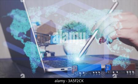 Global Logistics and E-Commerce Innovation Workspace with Hand Using Stylus on Laptop Displaying World Map, Miniature Toy Trucks, Shopping Cart, Green Stock Photo