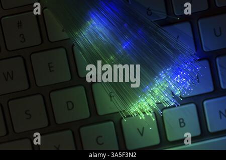 Colourful optic fibers illuminated on keyboard. High speed internet concept. Data transfer optic fiber cable. Bunch of many optical fibers, glowing di Stock Photo