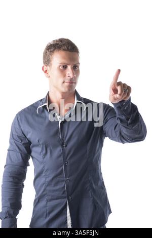 Attractive young man pressing imaginary button in the air with his finger. Isolated on white Stock Photo