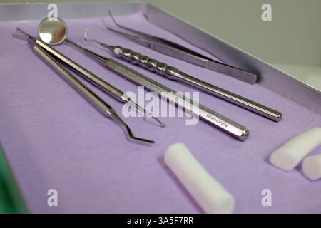 Tools of a dentist: mouth mirror, tweezers, hook, scaler, burnisher and cotton rolls Stock Photo