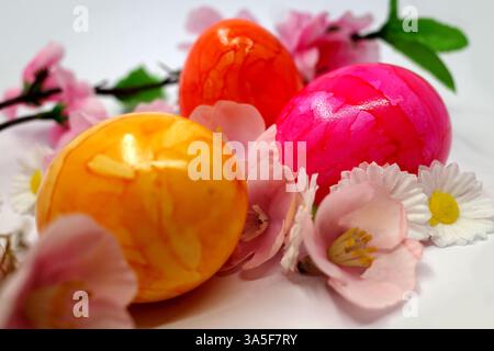 Brightly colored Easter eggs among spring flowers made of fabric Stock Photo