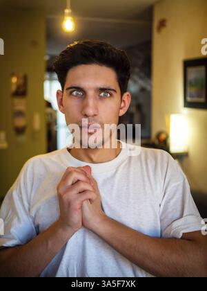 Surprised, scared, frightened, unsure handsome young man looking away Stock Photo