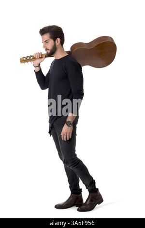 Full Length Portrait of Young Man Wearing Black Outfit Playing Classic Guitar in Studio with White Background Stock Photo