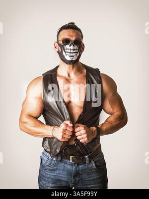 Handsome muscular man with mask over face as a robber or bandit in studio shot Stock Photo