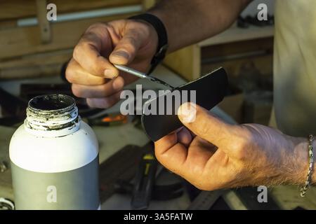 Tailor process leather in workshop. Making leather products Stock Photo
