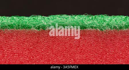 Two-color, two-layer dishwashing sponge close-up on a dark background. Macro photography. Stock Photo