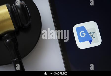 A close up of an iPad screen displaying the google translate app alongside a judge's gavel Stock Photo