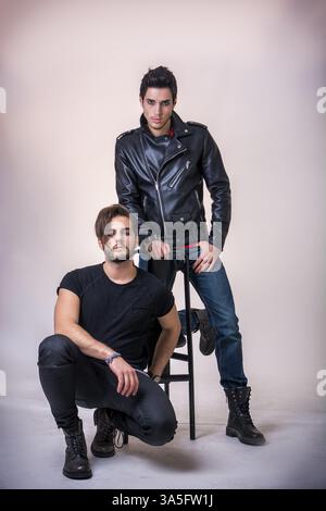 Two attractive young hard rock men posing in studio. White background Stock Photo
