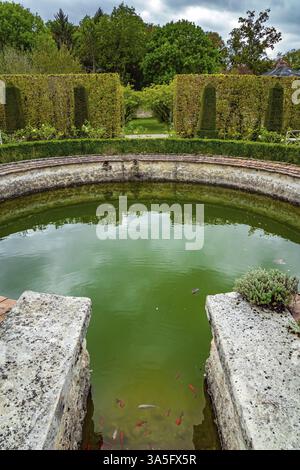 Picturesque round pool in the park greenhouse. Thepossession of Puss in Boots. Graceful bosquets surround the pool in Breteuil Park. Castle of Breteui Stock Photo