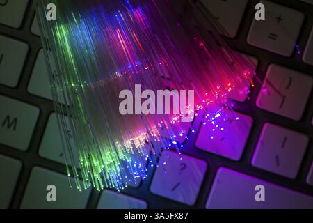 Colourful optic fibers illuminated on keyboard. High speed internet concept. Data transfer optic fiber cable. Bunch of many optical fibers, glowing di Stock Photo