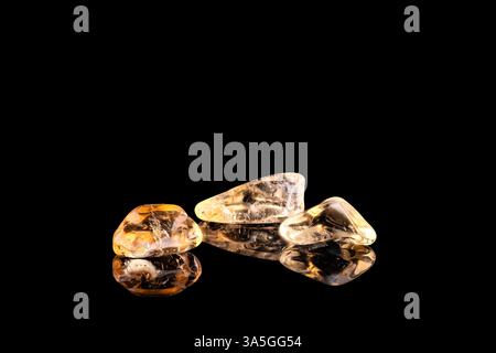 Polished yellow citrine quartz crystals isolated on black background Stock Photo