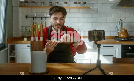 Chef demonstrating knife skills while recording a cooking tutorial Stock Photo