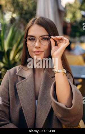 Wearing the glasses. Pretty young woman is outdoors. Stock Photo