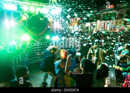 People celebrating on a street, dancing behind a truck with radio speakers and lightshow and foam, traditinal indian wedding in gunupur, orissa Stock Photo