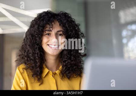Close-up photo, businesswoman at work with laptop inside office at workplace. Woman smiling contentedly pleased with results of achievement financier. Stock Photo