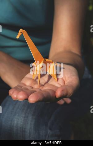 Origami orange color giraffe on hand Stock Photo