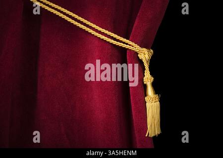 Red velvet curtain with tassel. Close up black isolated curtain Stock Photo
