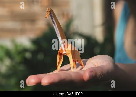 Origami orange color giraffe on hand Stock Photo