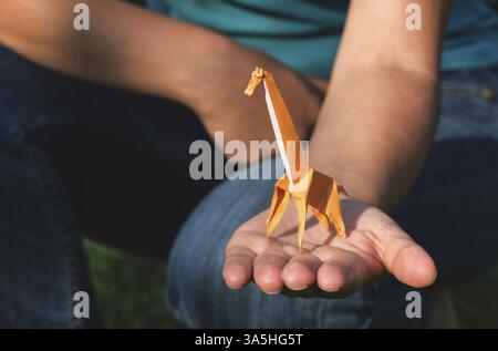 Origami orange color giraffe on hand Stock Photo