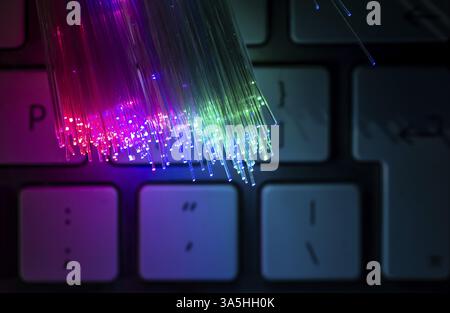 Colourful optic fibers illuminated on keyboard. High speed internet concept. Data transfer optic fiber cable. Bunch of many optical fibers, glowing di Stock Photo