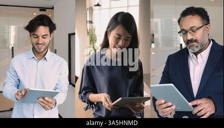 Three multinational teammates, business professionals standing in office holding modern tablets devices, checking e-mails, correspond to clients, usin Stock Photo