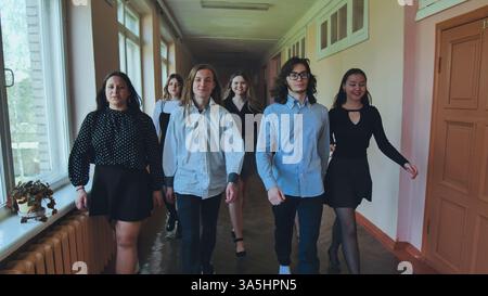 High school students happily strolling through the school hallway during their break, chatting and enjoying each other's company Stock Photo