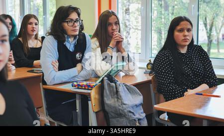 Teenage students are focused on their teacher during a school day in the classroom Stock Photo