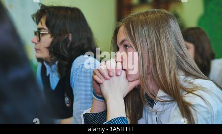 High school students listening attentively to the teacher during a class lesson, showing engagement and focus in their education Stock Photo