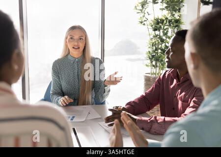 European female businesswoman holding meeting with managers. Diverse business partners discussing cooperation, teamwork strategy, brainstorming new id Stock Photo