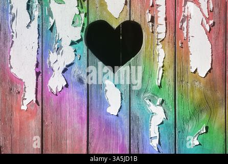 A heart shape cut out of a wooden board with peeling paint. Stock Photo
