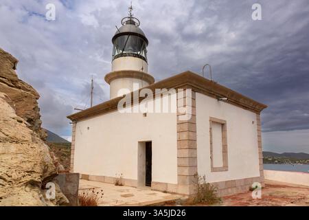 Coastal view of Far de Cala Nans lighthouse near Cadaques in Catalonia, Spain under cloudy skies Stock Photo