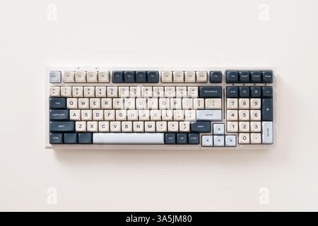 Modern mechanical keyboard on white background. Minimal style and design keyboard. Custom build keyboard. Colorful key blue and white cap. Top view. Stock Photo