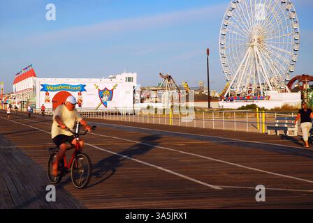 A senior man rides his bicycle along the boardwalk in Ocean City, New Jersey Stock Photo