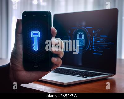 Multi factor authentication or 2FA concept. Digital key icon on smartphone screen in man hand and laptop computer with padlock symbol lock dashboard, Stock Photo