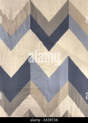 Close up of nylon fabric with arrow chevron V shape pattern in shades of blue, grey, and pale brown color. Fabric seamless background texture. Stock Photo