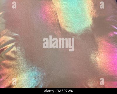 Unique holographic shiny satin fabric that reflects various color spectrum of rainbow colors. RGB color reflection and effect from a pink glossy fabri Stock Photo