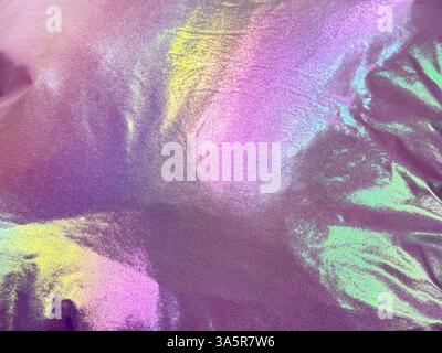 Unique holographic shiny satin fabric that reflects various color spectrum of rainbow colors. RGB color reflection and effect from a pink glossy fabri Stock Photo