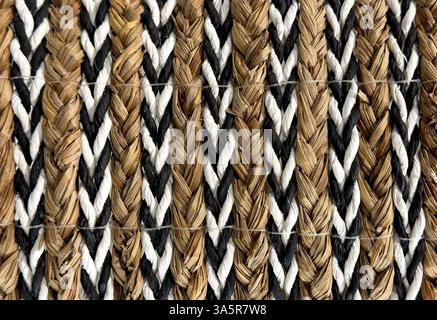 Close up of rattan basket with woven chevron pattern. Braided chevron V shape pattern in natural brown, black, and white colors suitable for a basket. Stock Photo