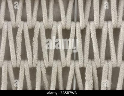 Close up of knitted linen basket in inverted chevron pattern. White basket with V shape chevron texture, woven and sewn in repetition. Seamless back Stock Photo
