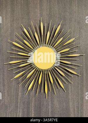 Beautiful sunburst mirror in gold paint color, suitable for wall panel decoration and accessories. Antique round shape with sunburst rays made of wrou Stock Photo