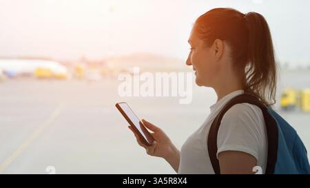 Tourist woman using smartphone at airport Stock Photo