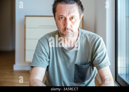 Portrait of pensive mature adult man at home, looking at camera, selective focus Stock Photo