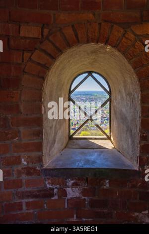 Cityscape view through a old window in a brick tower Stock Photo