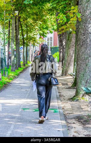 Rear view of French African woman with ling braided hair - Paris, France. Stock Photo