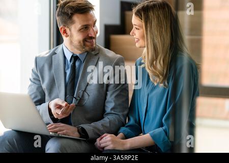 Happy businesspeople laughing while collaborating on a new project in an office. Stock Photo